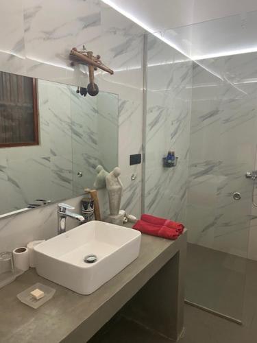 a white bathroom with a sink and a shower at Emel's Retreat in Busse