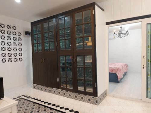 a room with a large wooden cabinet with glass doors at At Night in Chumphon
