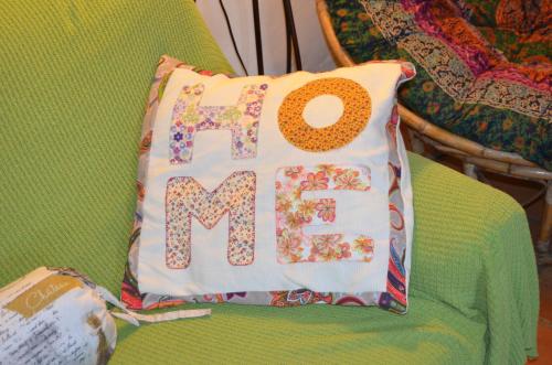 a pillow with the word me sitting on a green chair at La Casa Del Teix in Eslida