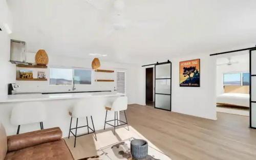 cocina y sala de estar con encimera y taburetes en Modern & Private Desert Home w/ ez access and near Joshua Tree, en Twentynine Palms
