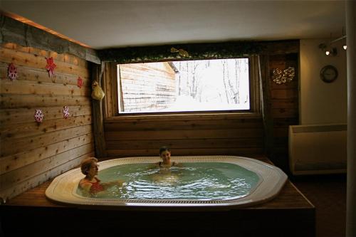 two children swimming in a bath tub in a room at Résidence Les Fermes Du Planet - Pièces 74 in Valloire