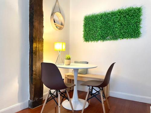 a table and chairs in a room with a green wall at FIKA FLAT Casco ViejoPARKING 15 x día in Bilbao