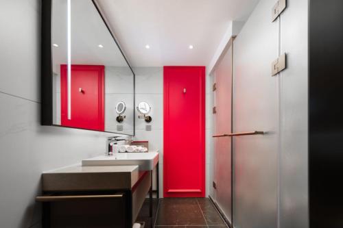 a bathroom with red cabinets and a red door at Mövenpick by Accor Binjiang Nanjing in Nanjing