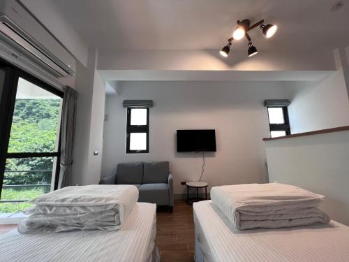 a bedroom with two beds and a tv and a couch at Dawn Valley in Green Island