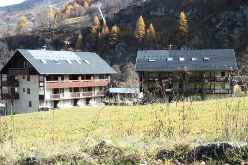 a large building in a field next to a mountain at Résidence Plan Soleil - 2 Pièces pour 4 Personnes 24 in Valloire