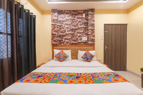 um quarto com uma cama com um edredão colorido em FabHotel Swarn Banquet em Kakarmatha
