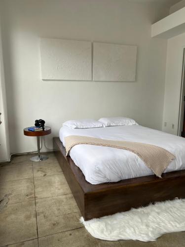 a bedroom with a bed and a table with avertisement at Historic Downtown LA Loft - Urban Charm in Los Angeles