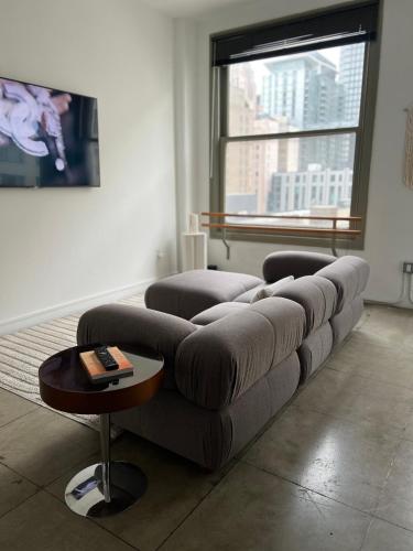 a couch in a living room with a large window at Historic Downtown LA Loft - Urban Charm in Los Angeles