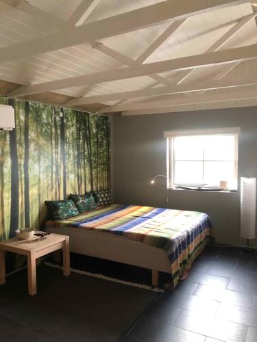 Un dormitorio con una cama y una mesa. en Really Nice And Big Summerhouse Close To Roskilde Fjord, en Ølsted