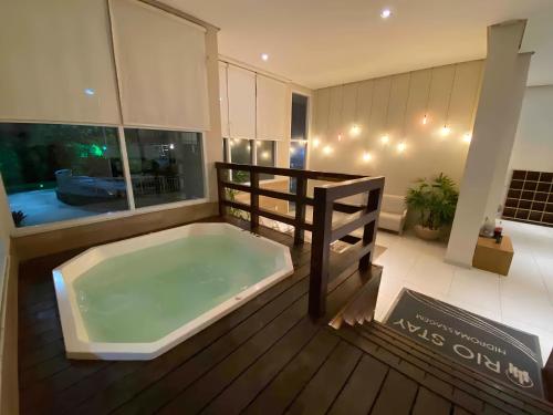 a large bath tub sitting on top of a wooden deck at Suíte & Flat Premium Rio Stay - Rio Centro in Rio de Janeiro