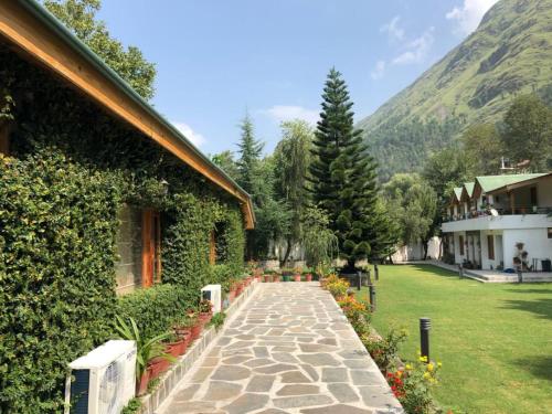 a stone walkway next to a house with a mountain at Smile Resort , Himachal Pradesh in Shamshi