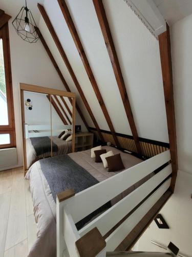een slaapkamer met een bed en een spiegel bij Gite Delphine in Kaysersberg