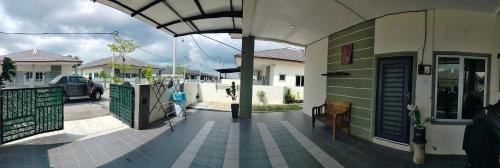a building with a walkway in front of a street at Doleena's Homestay in Sitiawan
