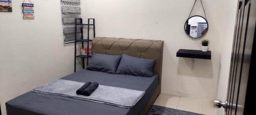 a small bedroom with a bed with a mirror at Doleena's Homestay in Sitiawan