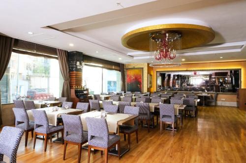 restauracja ze stołami i krzesłami oraz żyrandolem w obiekcie ARMİS HOTEL w mieście Konak