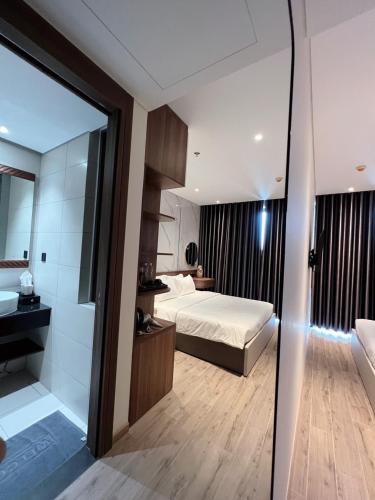 a hotel room with a bed and a bathroom at Luna Apartment - Apec Mandala Phú Yên in Tuy Hoa