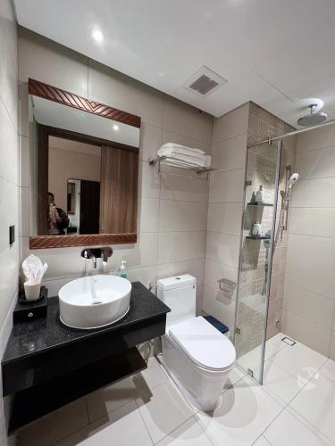 a bathroom with a sink and a toilet and a shower at Luna Apartment - Apec Mandala Phú Yên in Tuy Hoa