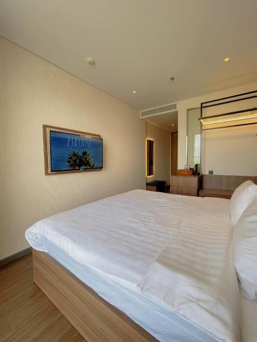 a bedroom with a large white bed in a room at Luna Apartment - Apec Mandala Phú Yên in Tuy Hoa