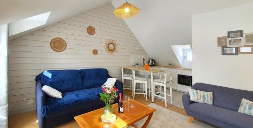 a living room with a blue couch and a table at Appartement Ty Cosy in Quiberon