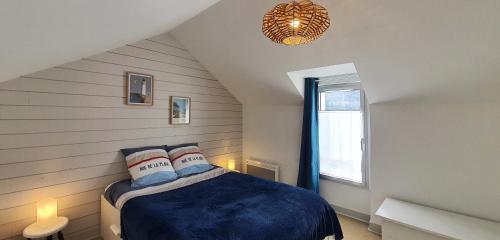 a bedroom with a blue bed in a attic at Appartement Ty Cosy in Quiberon