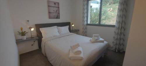 une chambre avec un lit avec des serviettes dessus dans l'établissement Corse et Zen VILLA SUR LES BOIS 85m2 5à7 pers, à Taglio-Isolaccio