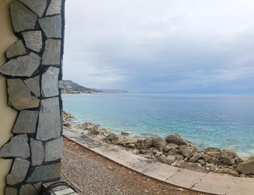 a view of the ocean from a stone wall at House next to the sea side in Derveni