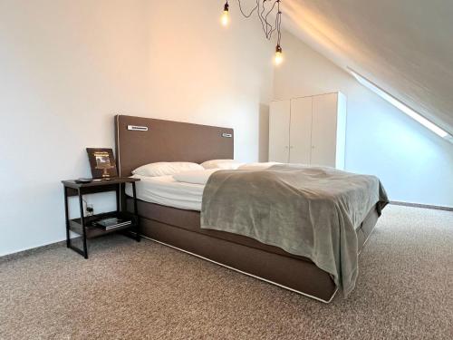 a bedroom with a bed and a side table at Modernes Apartment mit Blick zur Elbe in Klipphausen