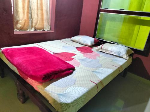 Una cama con una manta roja encima. en Sambrama Wood house, en Madikeri