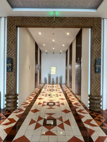an empty hallway with a checkered floor in a building at Luna Apartment - Apec Mandala Phú Yên in Tuy Hoa