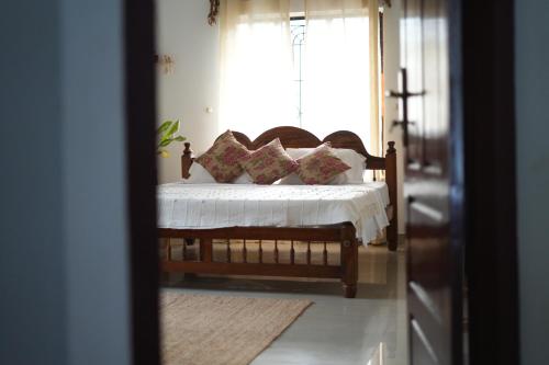 Heligans Yard - LADIES ONLY في فاركَالا: سرير مع وسائد في غرفة مع نافذة