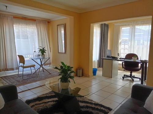 sala de estar con sofá y mesa en Olivia Pines Guesthouse, en Krugersdorp