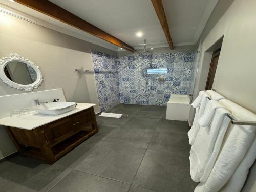 La salle de bains est pourvue d'un lavabo, de toilettes et d'un miroir. dans l'établissement De Akker Guest House Louis Trichardt, à Louis Trichardt