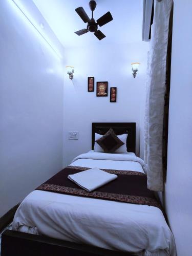 a bedroom with a bed with a ceiling fan at Hotel Shannti Inn in Varanasi