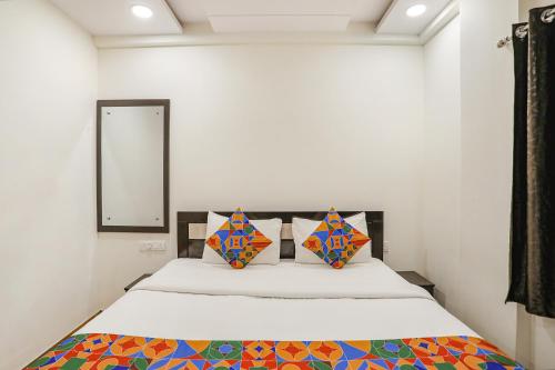 a bedroom with a bed and a mirror at FabHotel Royal Stay in Nagpur