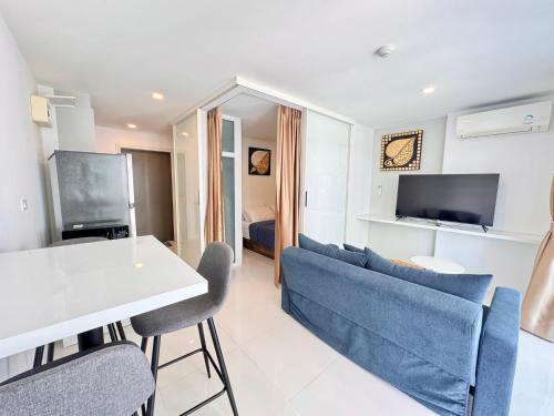 a living room with a blue couch and a table at Mantra Beach Condominium Suite - Mae Phim in Ban Tha Fat