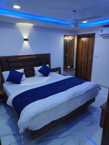 a bedroom with a large bed with blue lighting at Hotel Palak Palacce in Ahmedabad