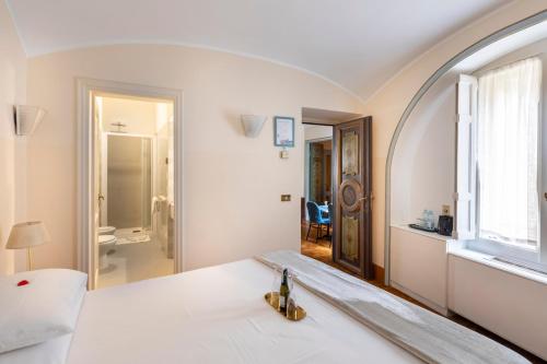 a white room with a bed with a mirror at Martina House in Rome