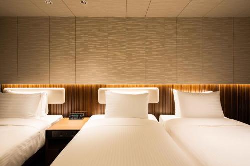 two beds in a hotel room with two beds sidx sidx sidx at Sotetsu Fresa Inn Seoul Myeong-dong in Seoul