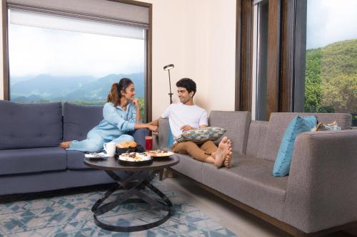 a man and woman sitting on a couch in a living room at Fairfield by Marriott Dehradun in Dehradun