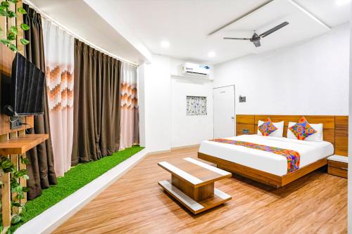 een slaapkamer met een kingsize bed en een televisie bij FabHotel 7 Star in Surat