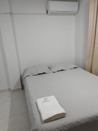 a bed with a white towel sitting on top of it at Kavala Anisa in Cartagena de Indias