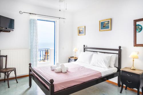 a bedroom with a large bed and a window at Blue and White in Otzias