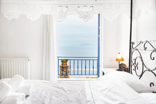 a bedroom with a bed with a view of the ocean at Blue and White in Otziás