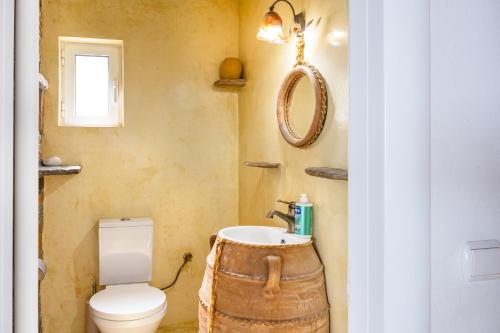 a bathroom with a toilet and a sink in a barrel at Blue and White in Otzias