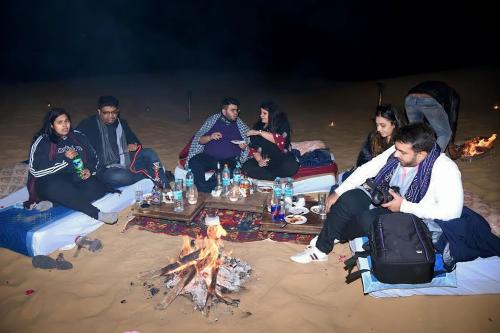 Un groupe de personnes assises autour d'un feu sur la plage dans l'établissement Hotel Sun Heaven Senerity, à Jaisalmer