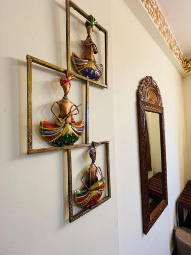 a wall with three pictures of a woman on a wall at Teerth Palace Pushkar in Pushkar