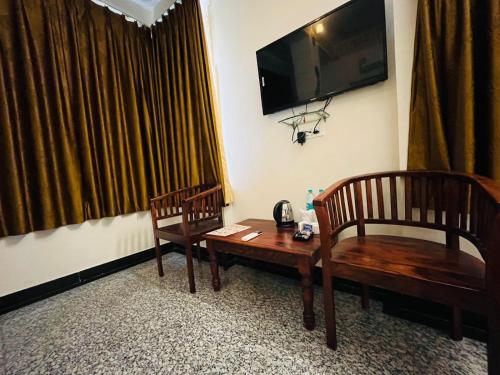a room with two chairs and a table and a television at Teerth Palace Pushkar in Pushkar