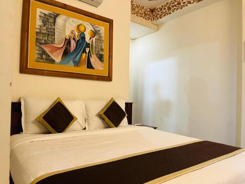 a bedroom with a bed with a painting on the wall at Teerth Palace Pushkar in Pushkar