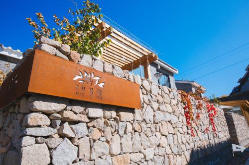 a stone wall with a sign on top of it at Simatai No.19 Villa in Miyun
