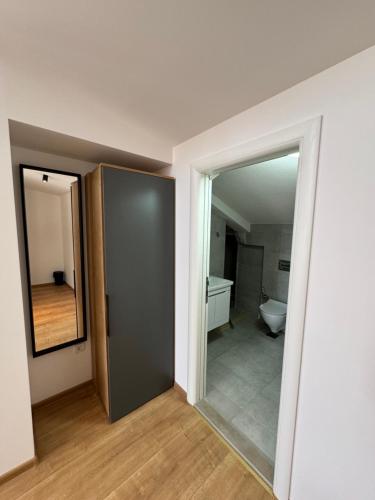 een lege kamer met een spiegel en een badkamer bij Triangle Rooms in Raška